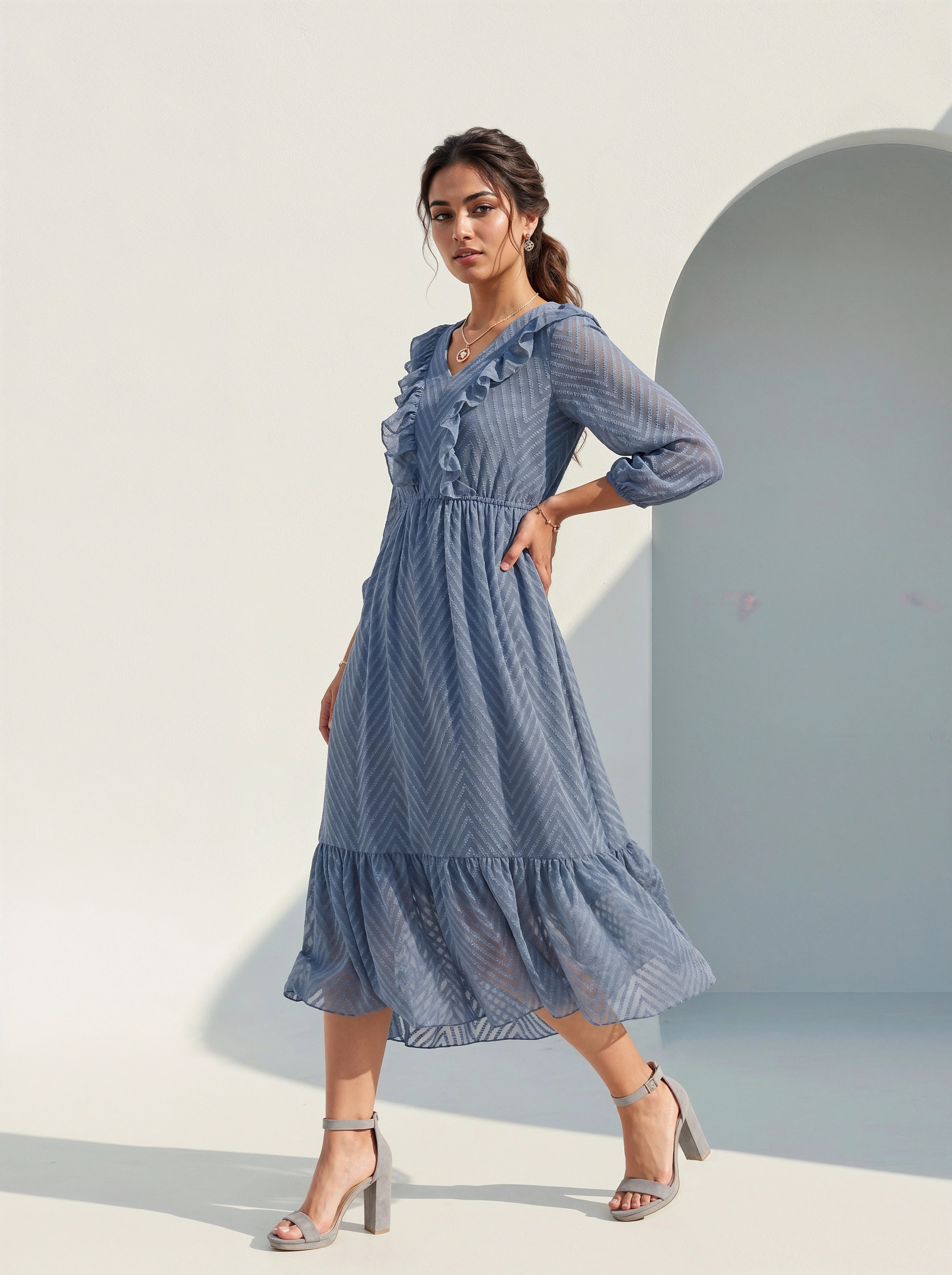Woman wearing a blue dress standing against a light background