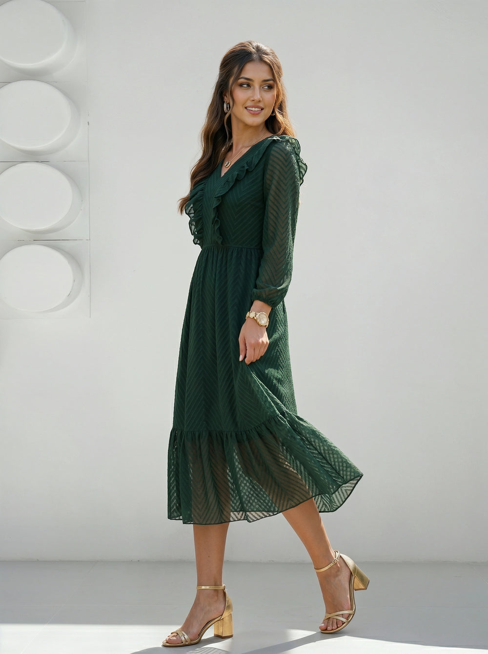 Woman wearing a green dress standing against a white background