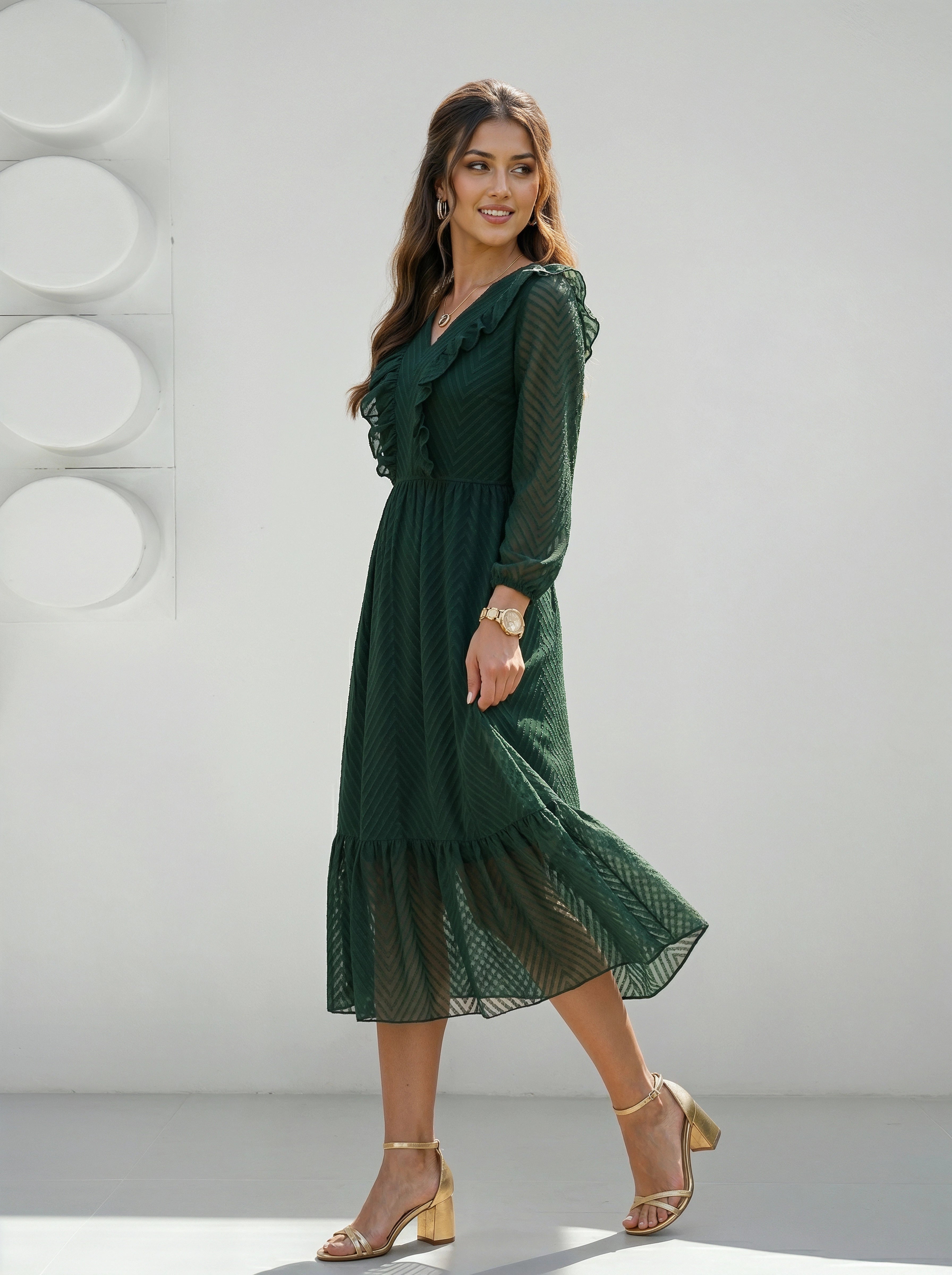 Woman wearing a green dress standing against a white background