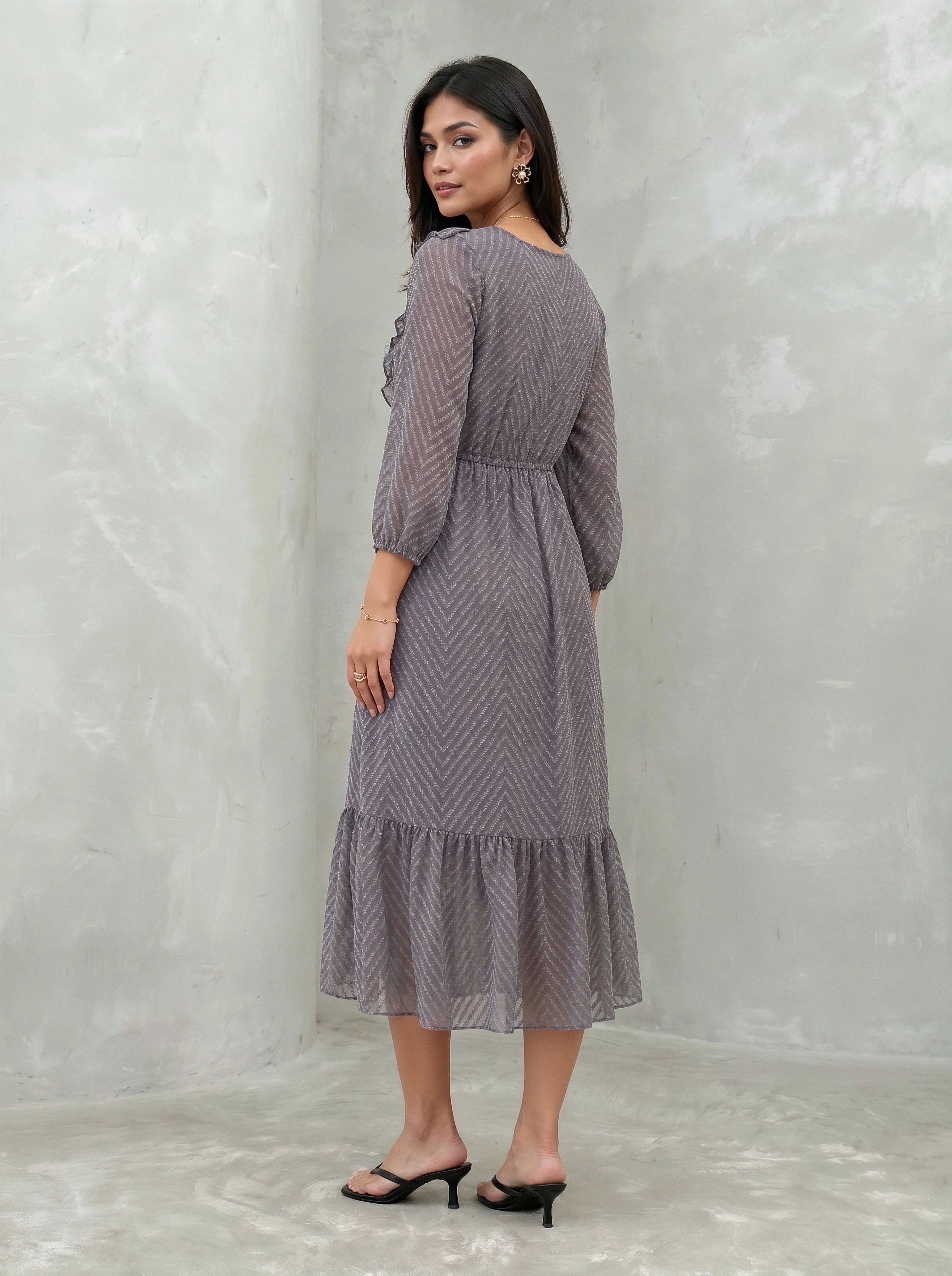Woman wearing a patterned dress against a plain background