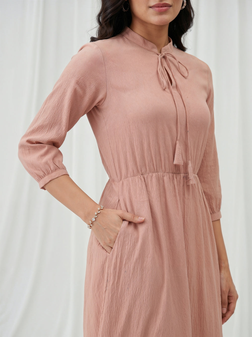 Woman wearing a pink dress with a white background