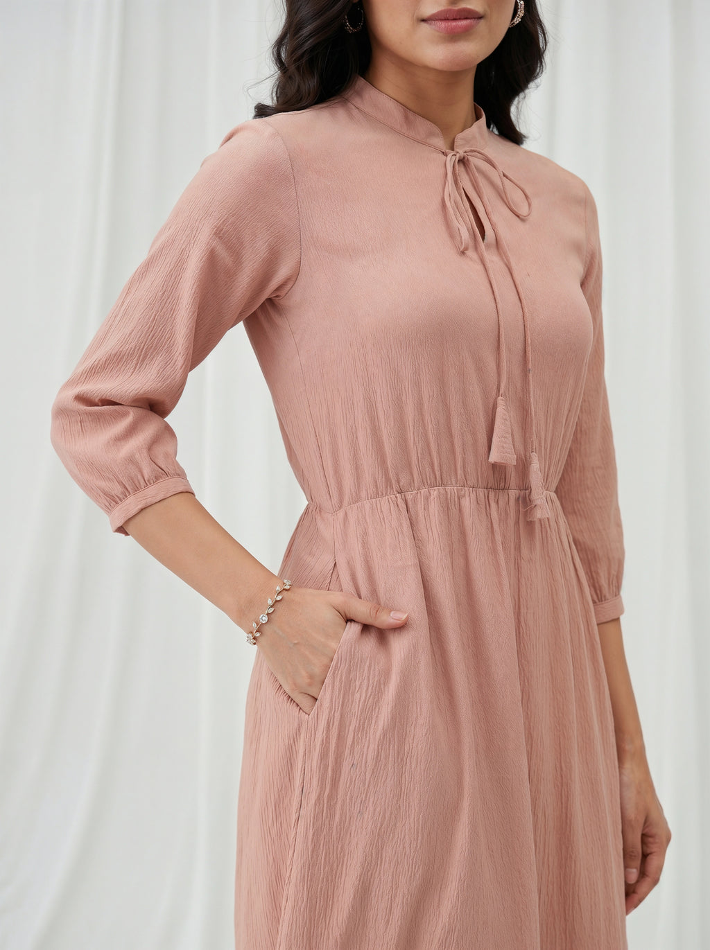 Woman wearing a pink dress with a white background