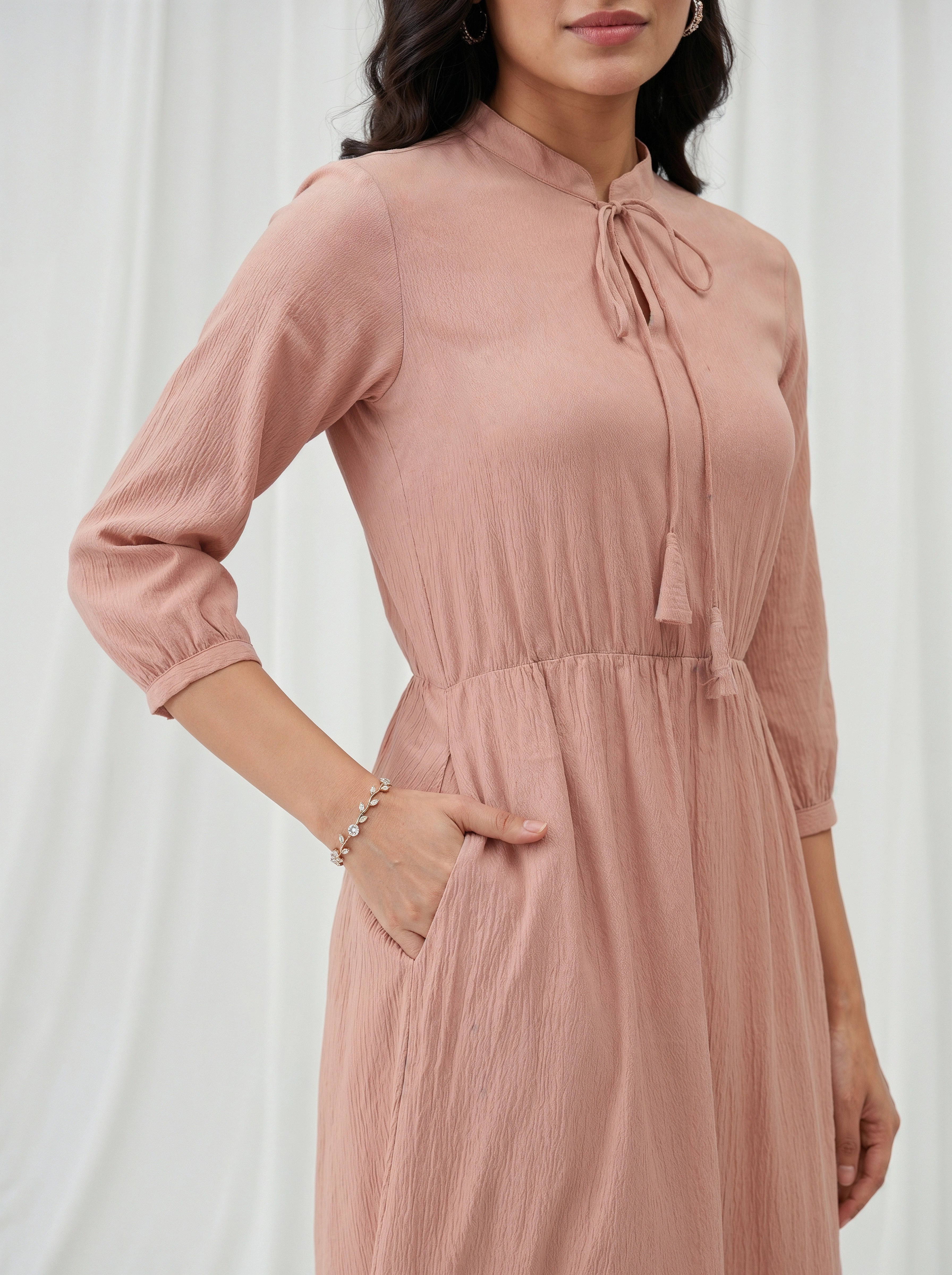 Woman wearing a pink dress with a white background