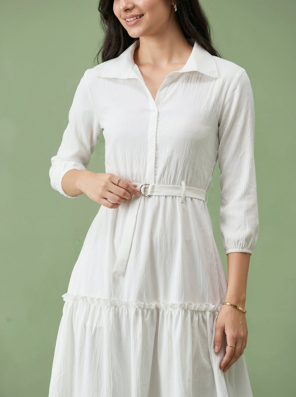 Woman wearing a white dress against a green background