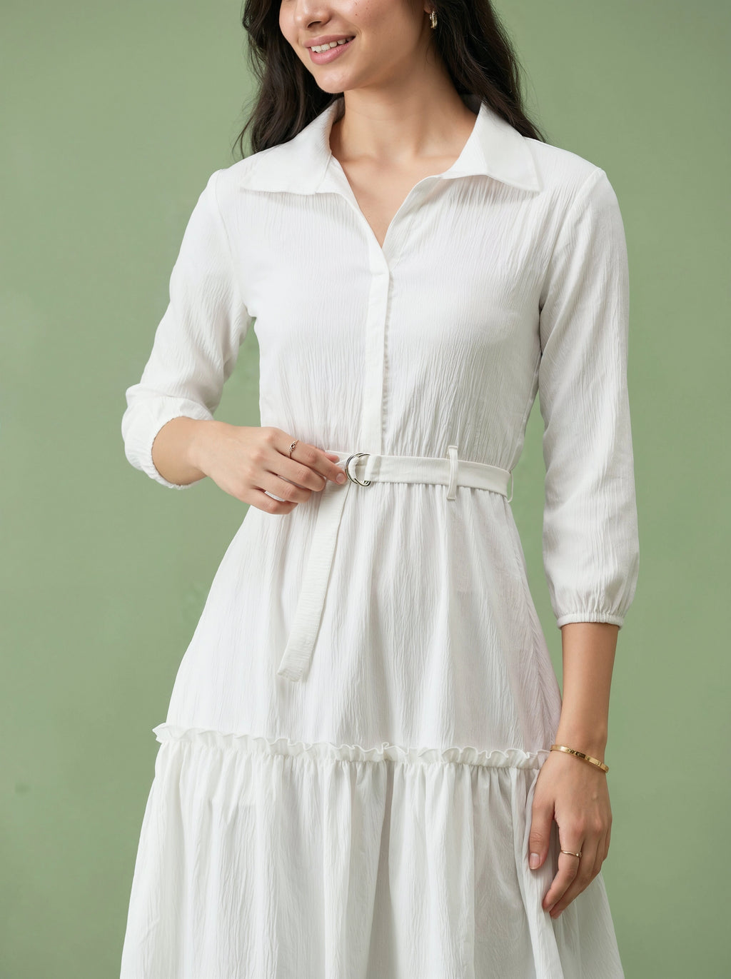 Woman wearing a white dress against a green background