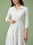 Woman wearing a white dress against a green background