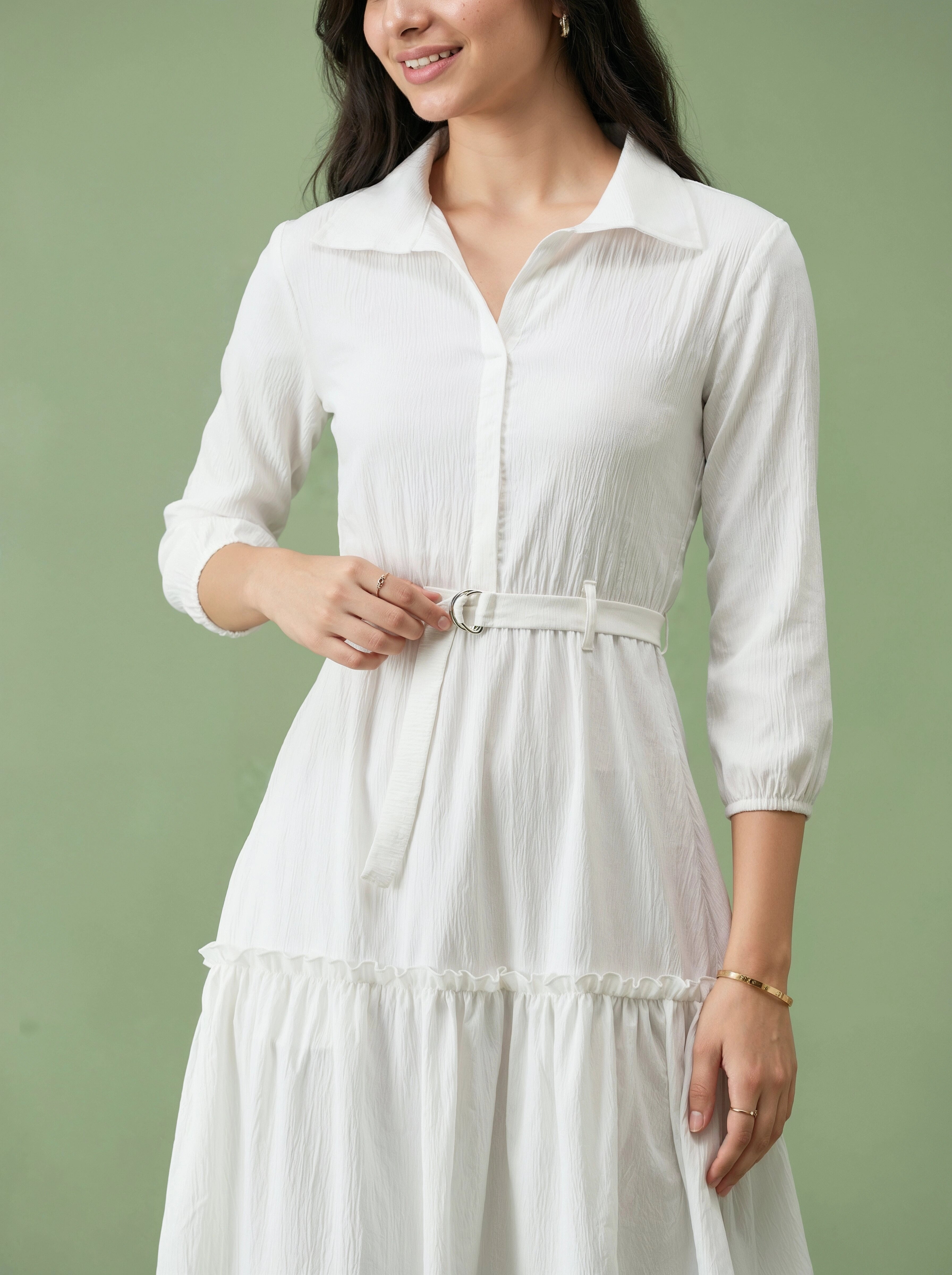 Woman wearing a white dress against a green background