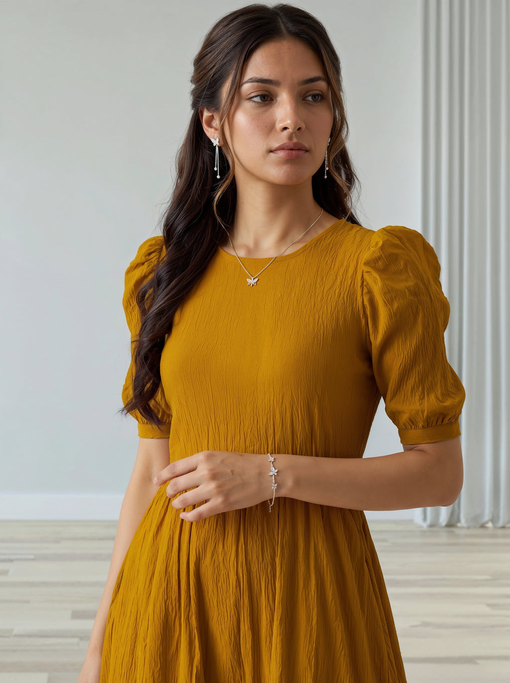 Woman wearing a mustard yellow dress with puffed sleeves in an indoor setting.