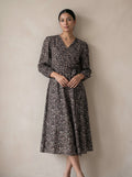Woman wearing a floral dress against a plain background
