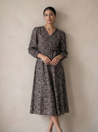 Woman wearing a floral dress against a plain background