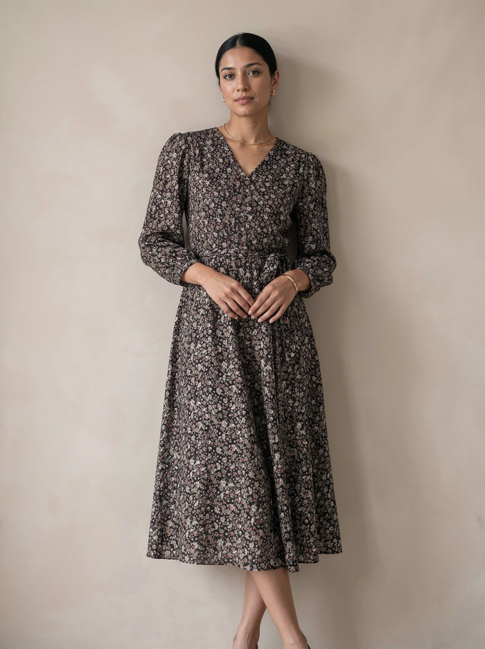 Woman wearing a floral dress against a plain background