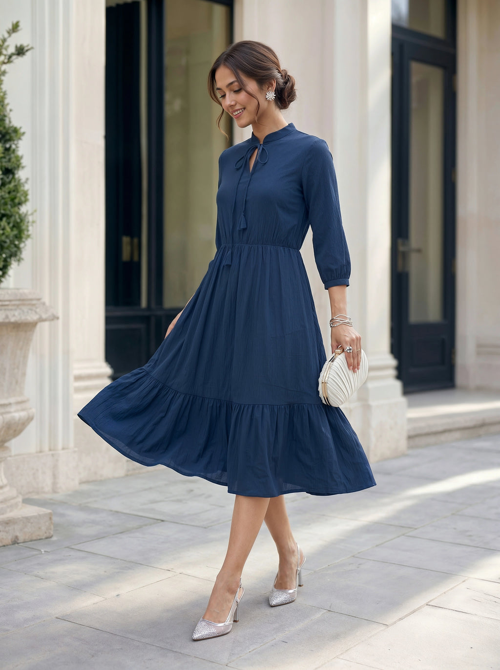 Woman in a blue dress standing in front of a building