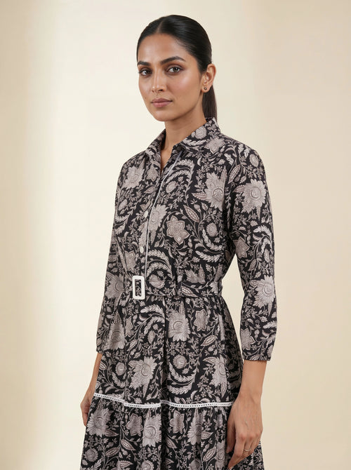 Woman wearing a black and white patterned dress against a beige background