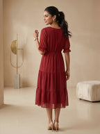 Woman wearing a red dress in a minimalistic room.