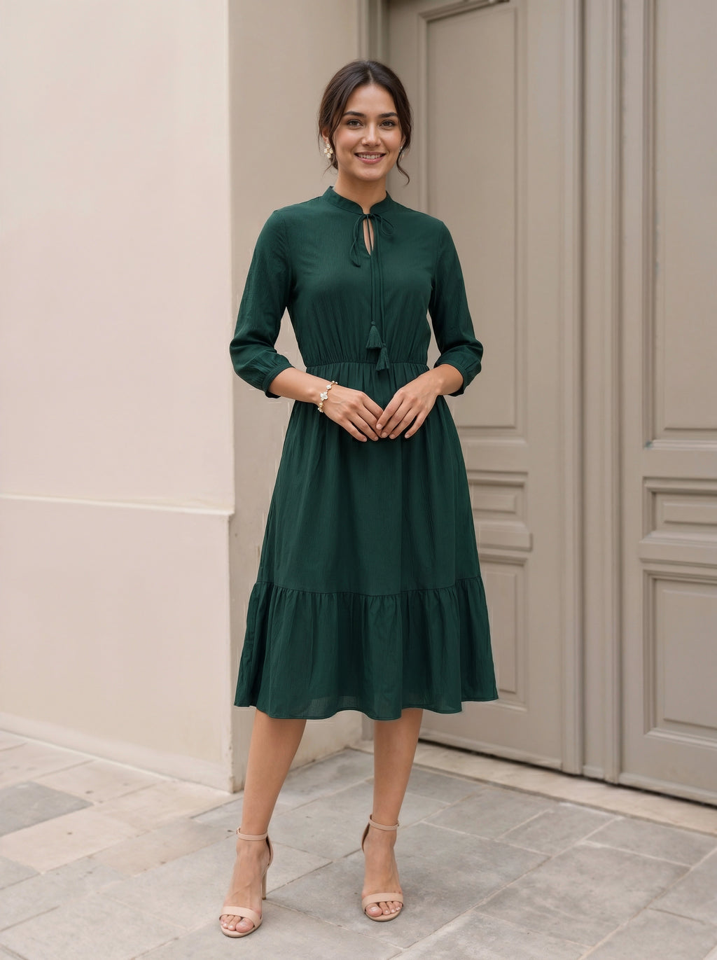 Woman wearing a green dress standing in front of a door.