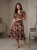 Woman wearing a floral dress standing in a room with a neutral background