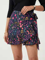 Person wearing a colorful floral wrap skirt on a white background