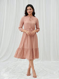 Woman wearing a pink dress against a white background