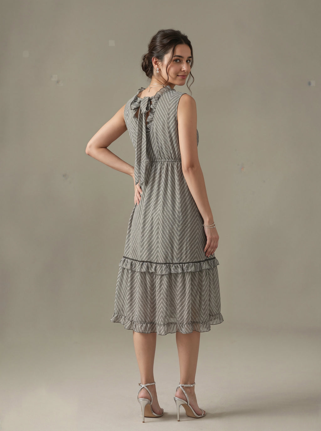 Woman wearing a patterned dress against a plain background