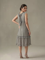 Woman wearing a patterned dress against a plain background