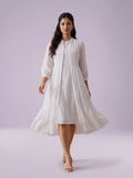 Woman wearing a white dress against a light purple background
