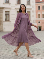 Woman wearing a purple dress with a matching cardigan in an urban setting