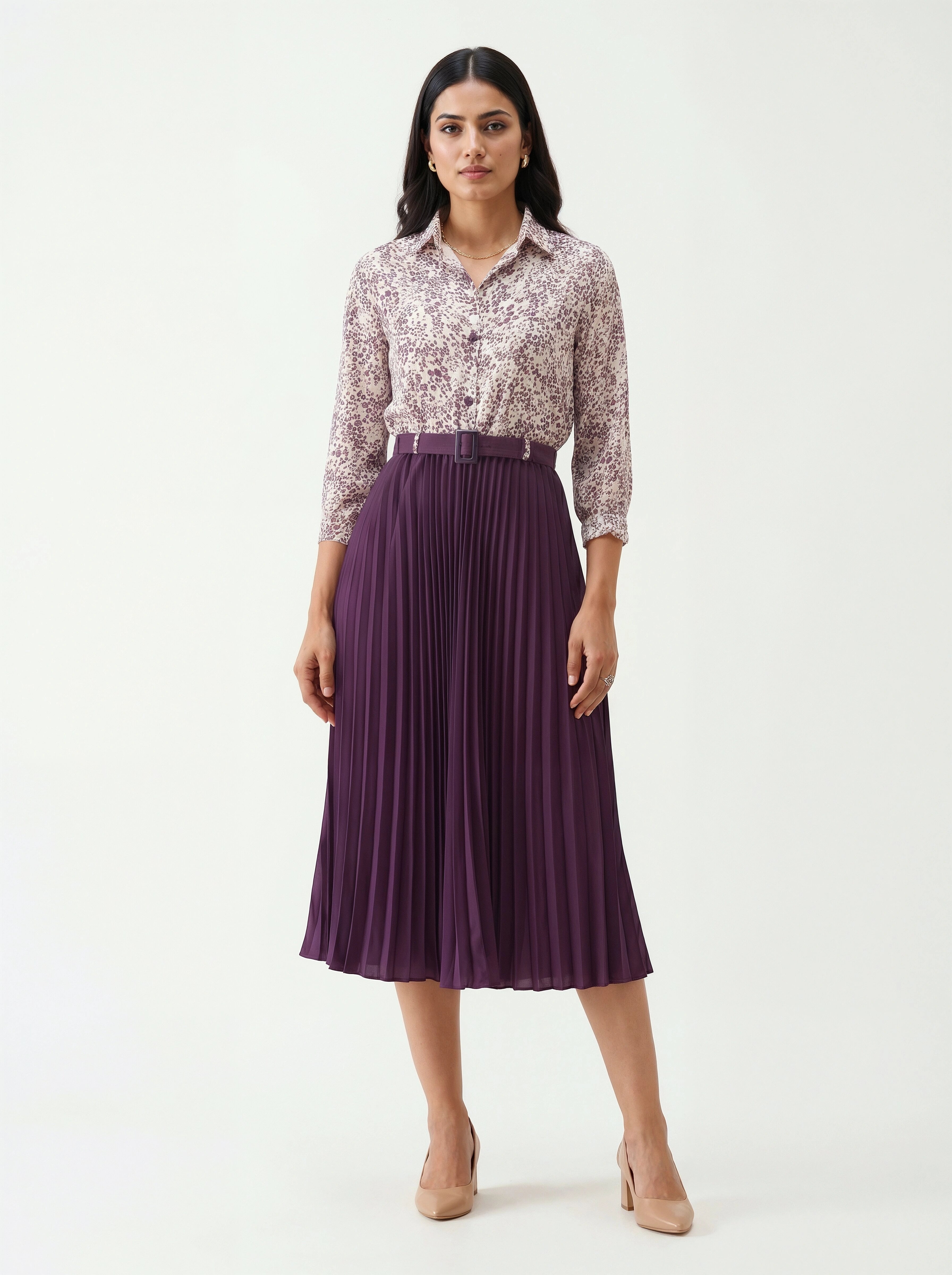 Woman wearing a floral blouse and purple pleated skirt on a white background