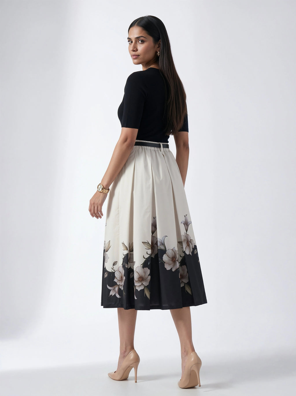 Woman wearing a black top and floral skirt on a white background