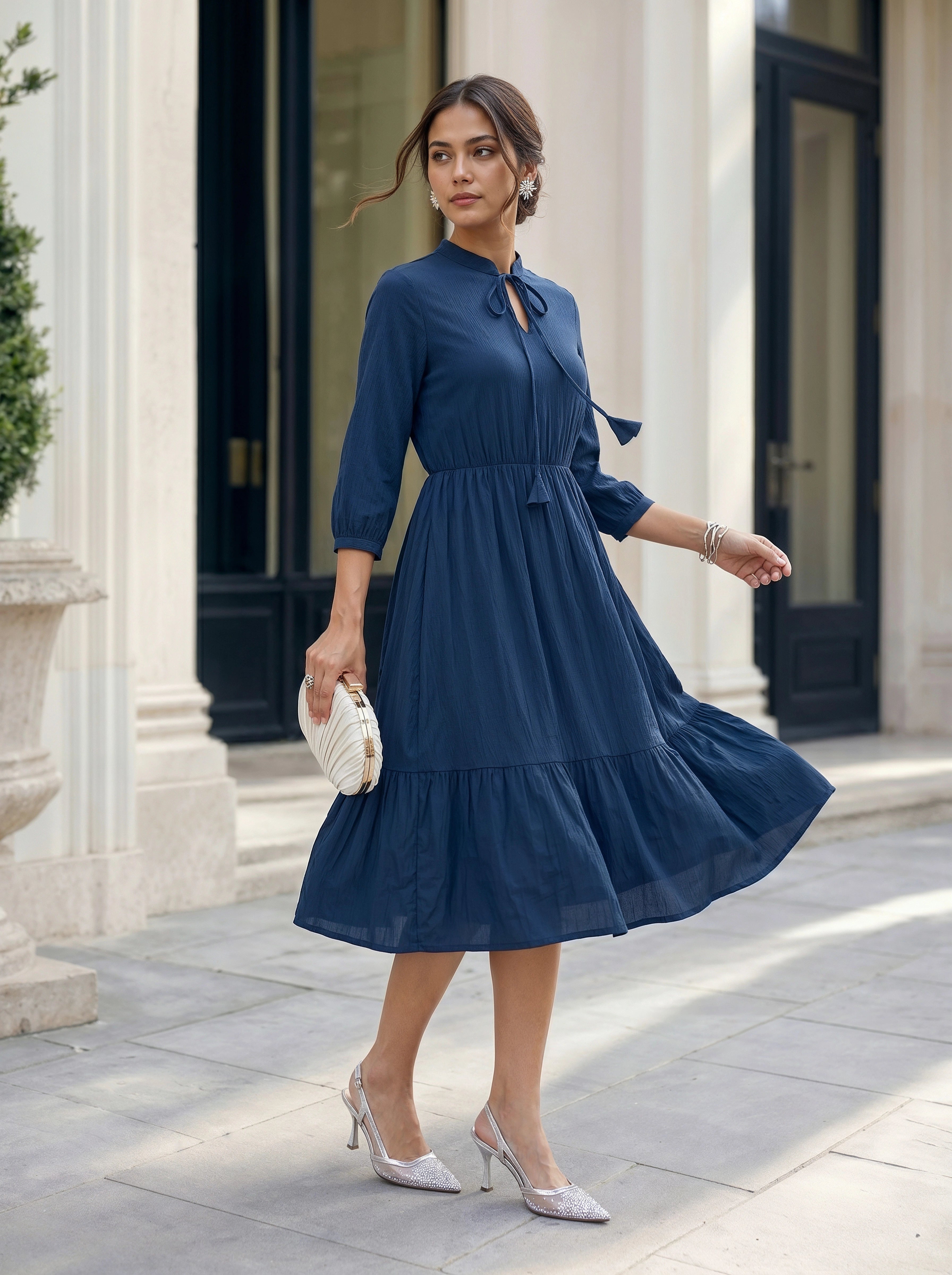Woman in a blue dress standing in front of classical architecture