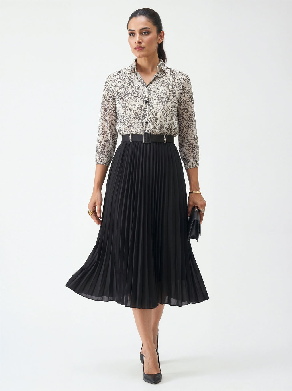 Woman wearing a floral blouse and black pleated skirt on a white background