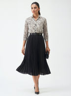 Woman wearing a floral blouse and black pleated skirt on a white background