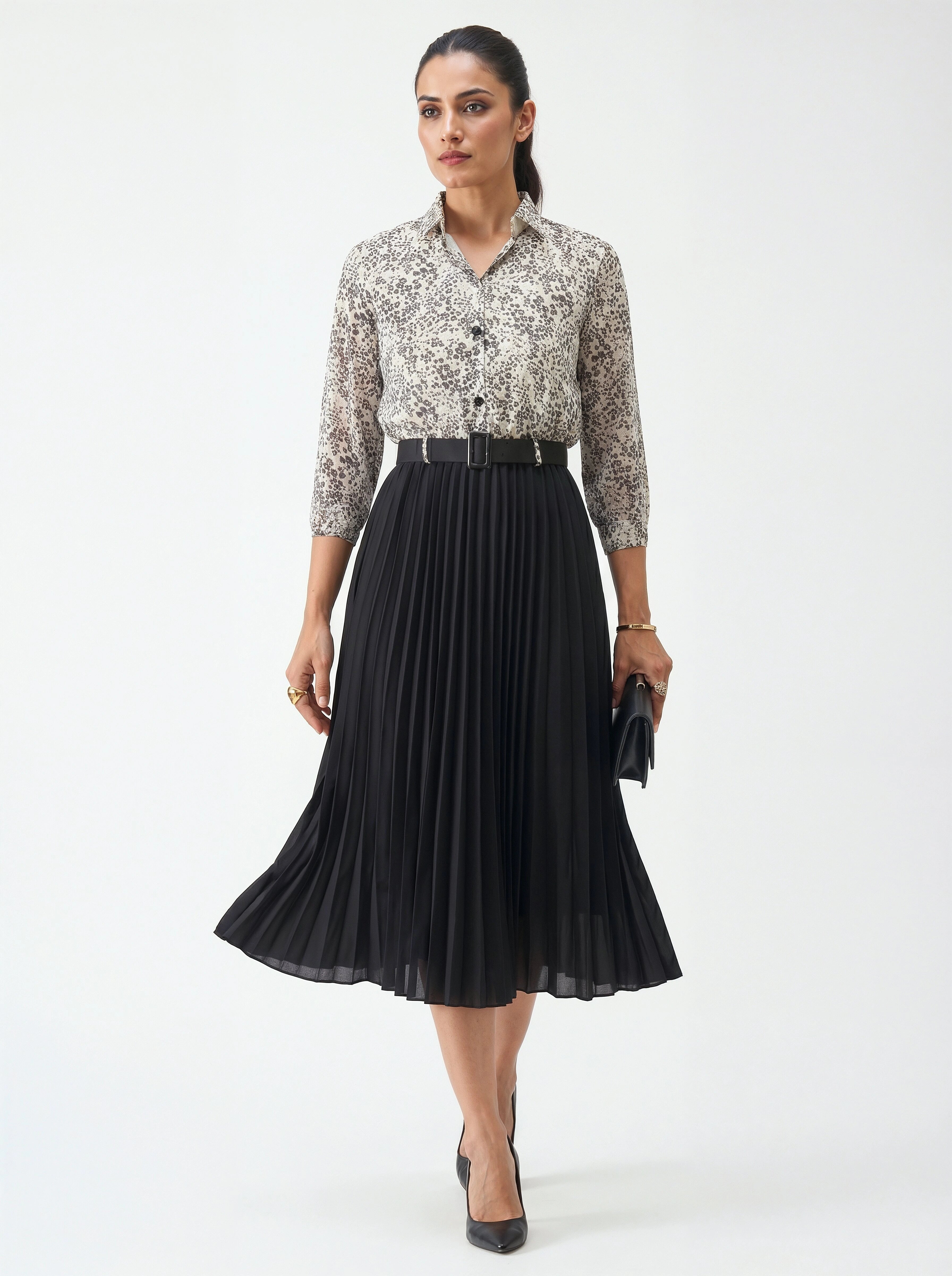 Woman wearing a floral blouse and black pleated skirt on a white background