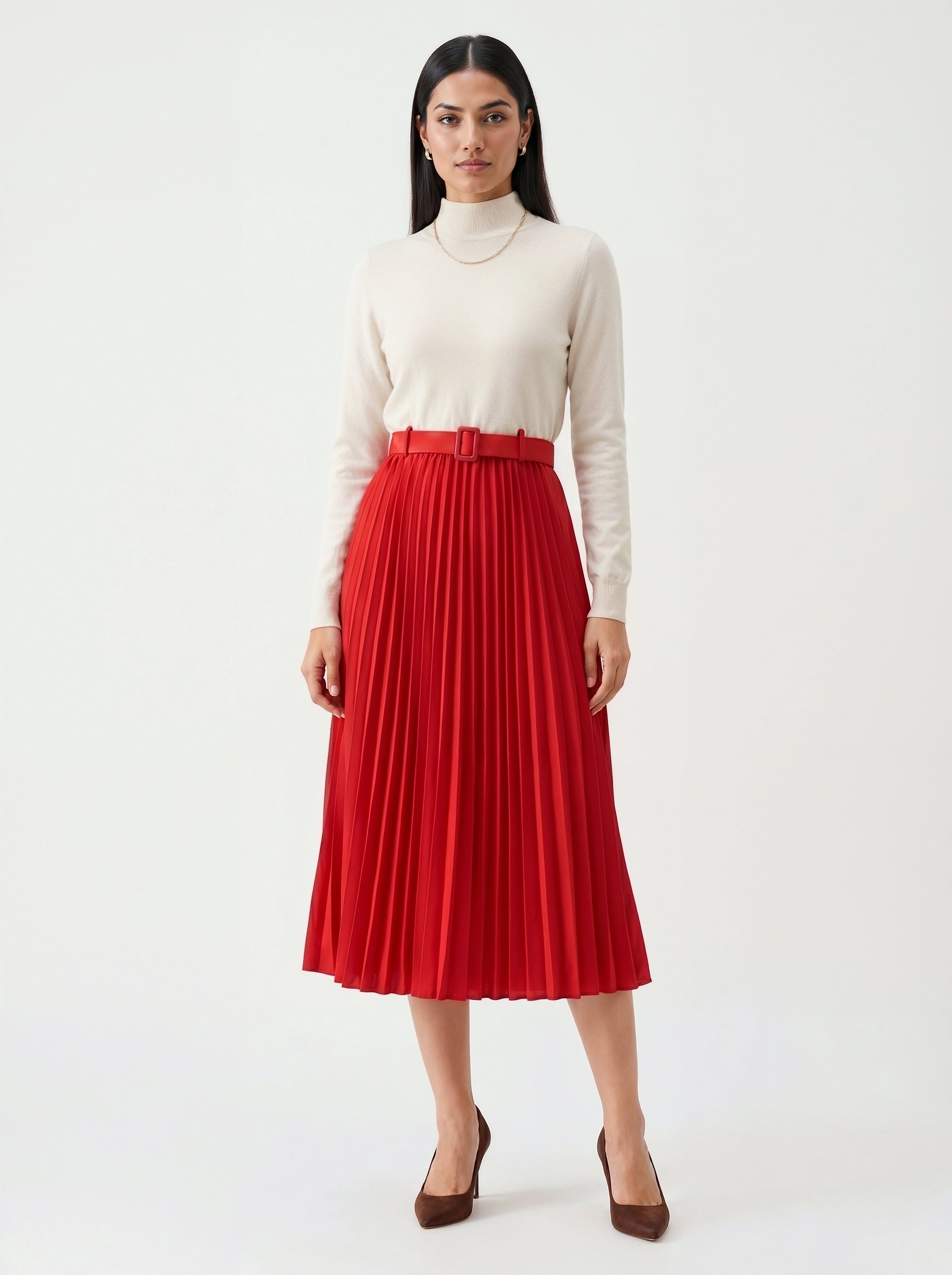 Woman wearing a red pleated skirt and cream turtleneck on a white background