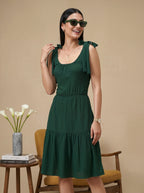 Woman wearing a green dress with ruffled sleeves in a casual setting.
