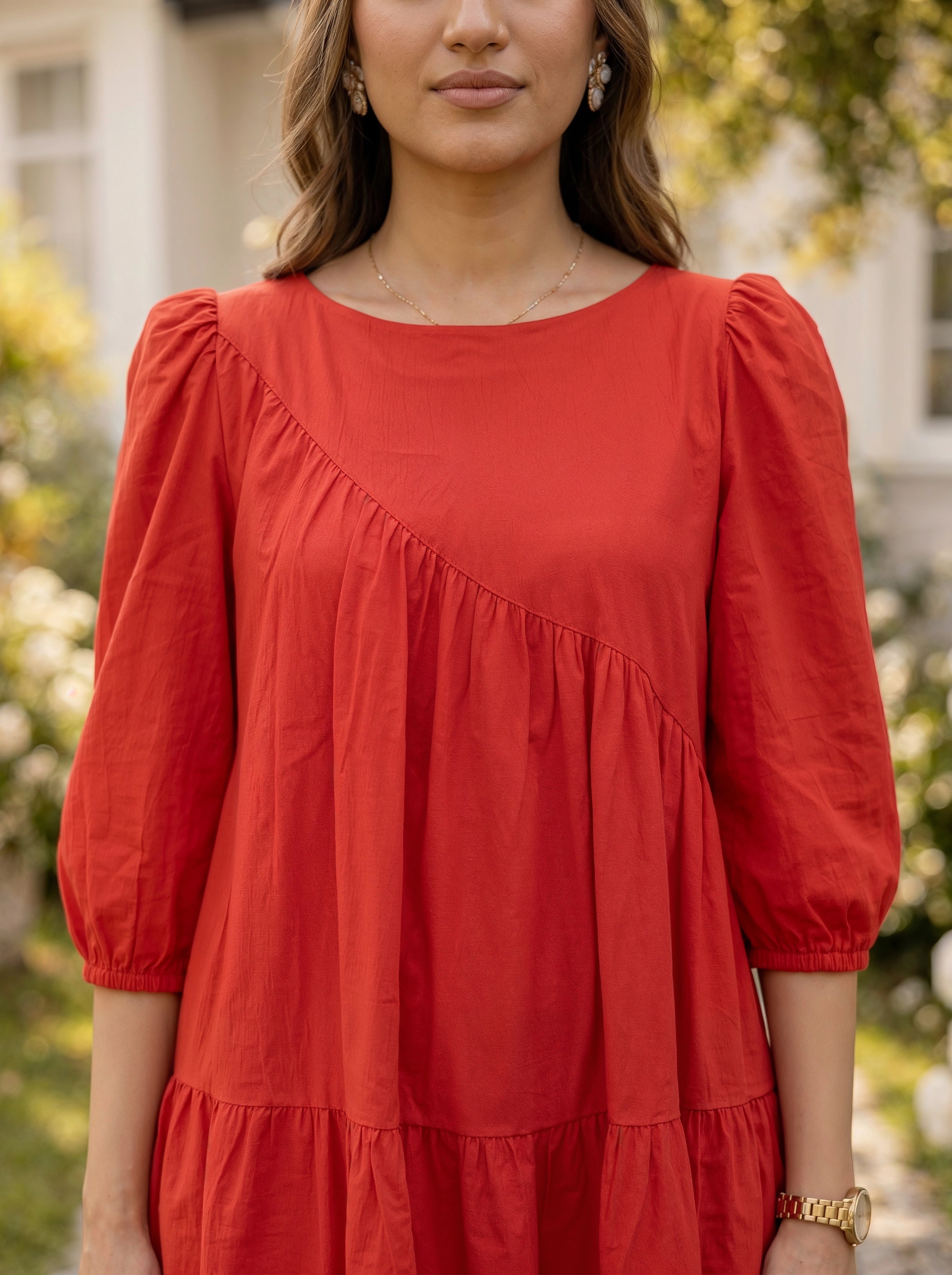 Woman wearing a red dress with puffed sleeves outdoors
