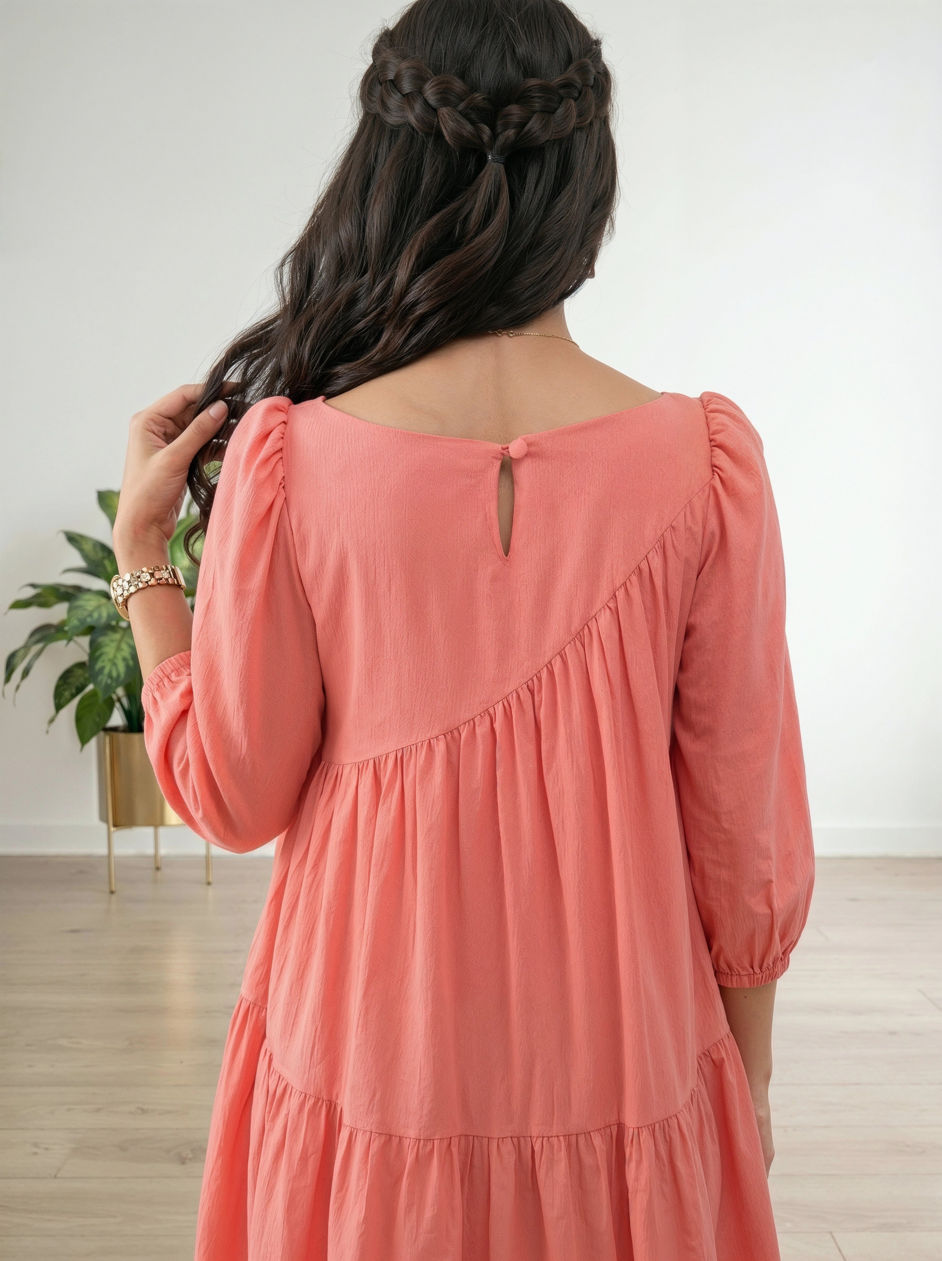 Woman wearing a coral dress with a white background