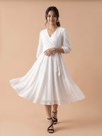 Woman wearing a white dress against a beige background