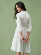 Woman wearing a white dress against a green background