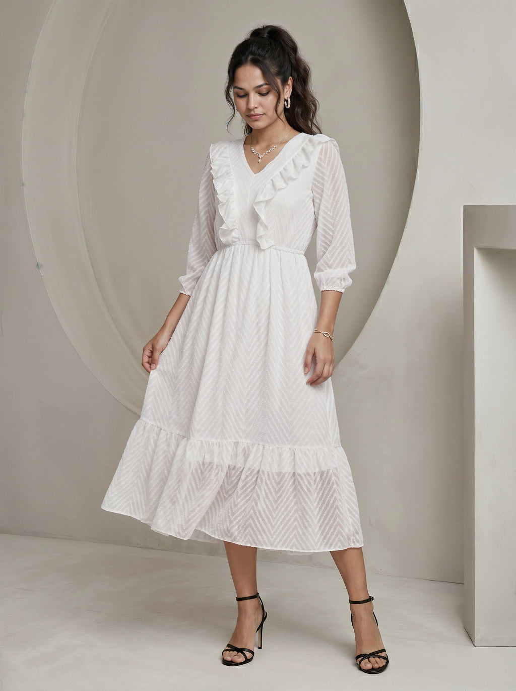 Woman wearing a white dress with ruffled details in a minimalistic setting