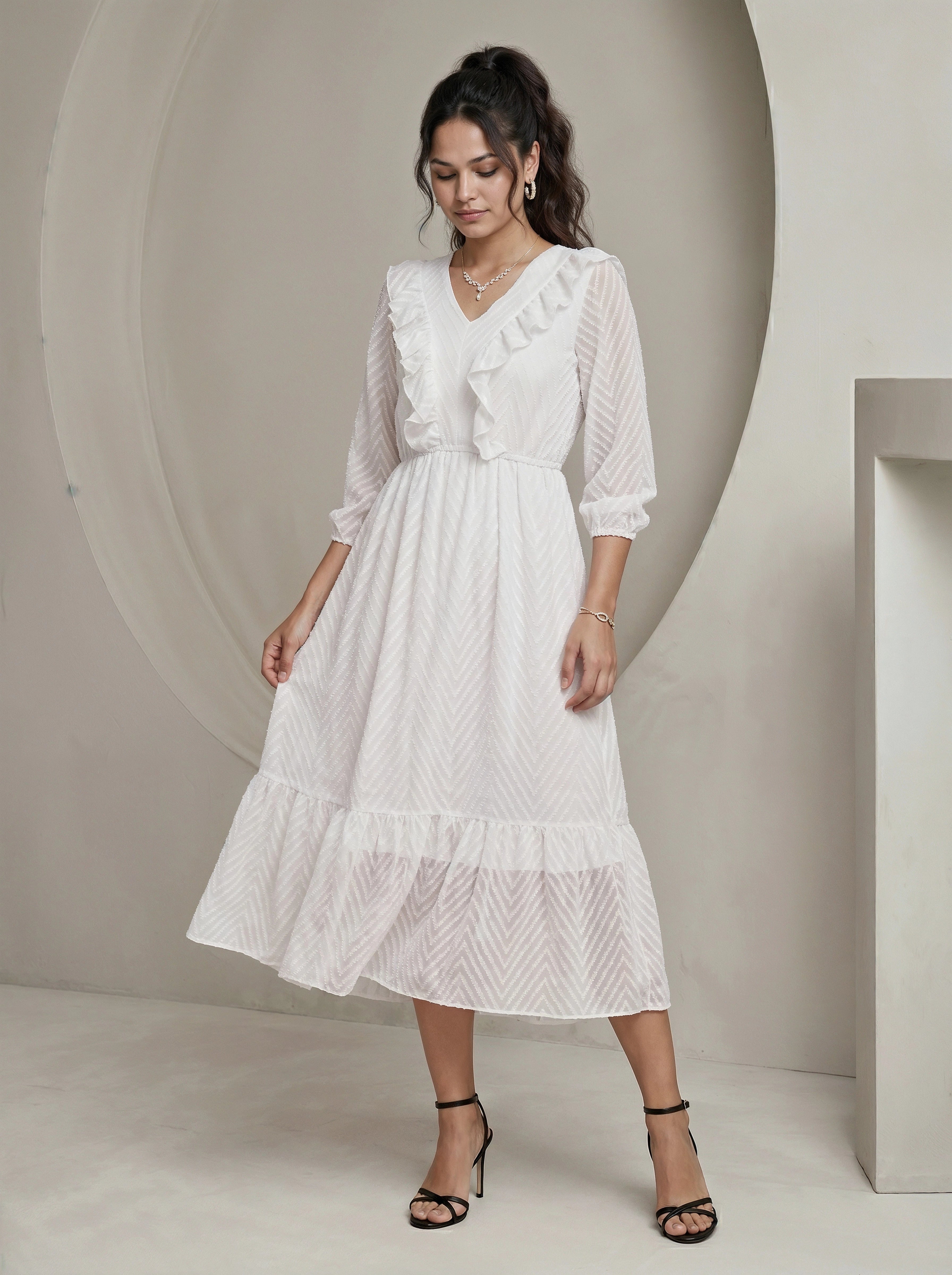 Woman wearing a white dress with ruffled details in a minimalistic setting