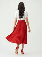 Woman wearing a white top and red pleated skirt on a white background