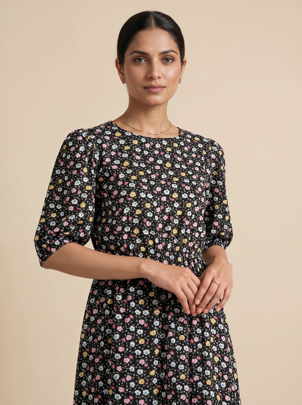 Woman wearing a black floral dress against a beige background