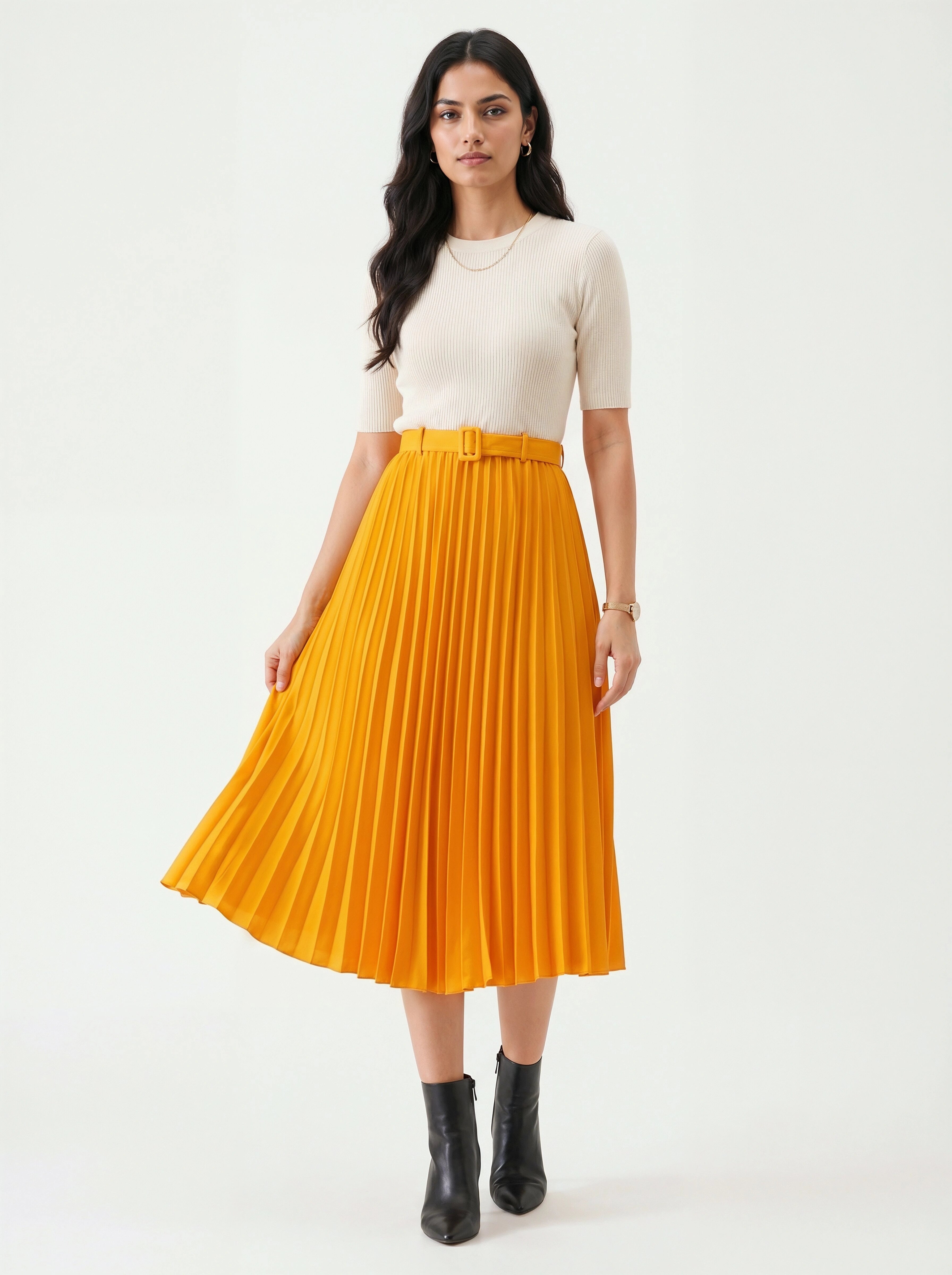 Woman wearing a yellow pleated skirt and white top on a white background