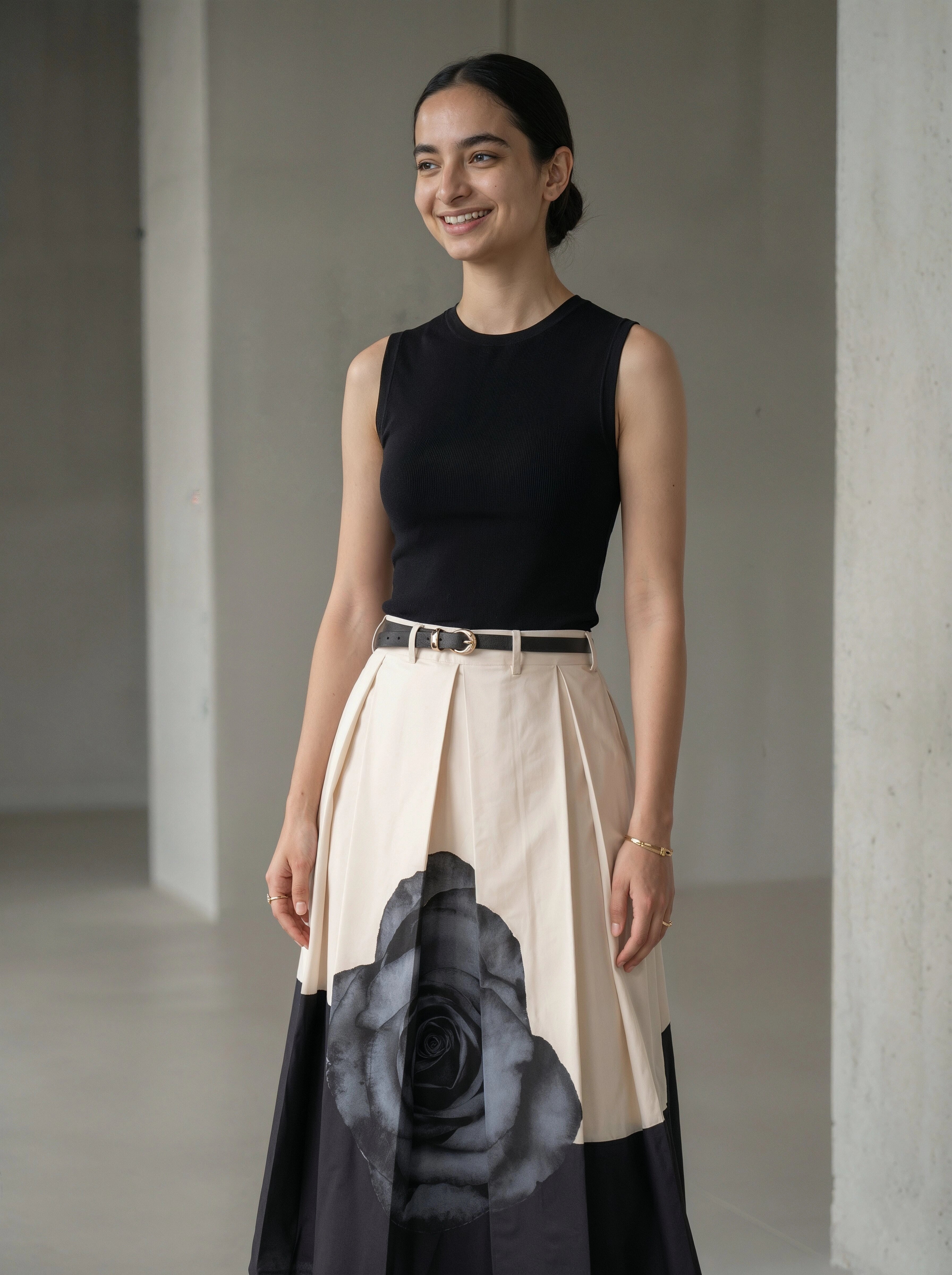 Woman wearing a black top and a floral skirt with a plain background