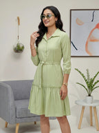 Woman wearing a light green dress in a living room setting