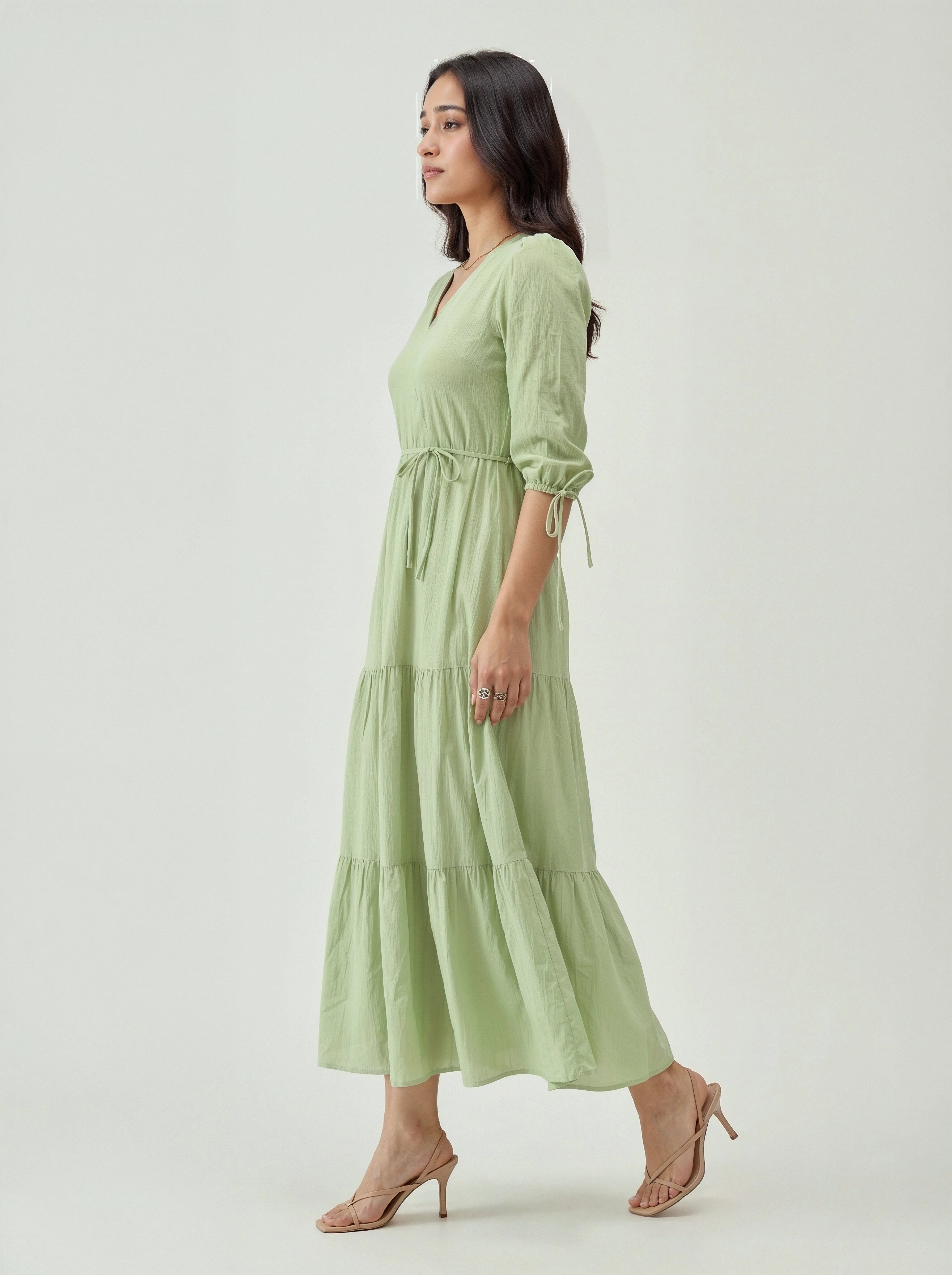 Woman wearing a light green dress on a white background