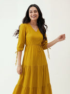 Woman wearing a yellow dress with puff sleeves on a white background