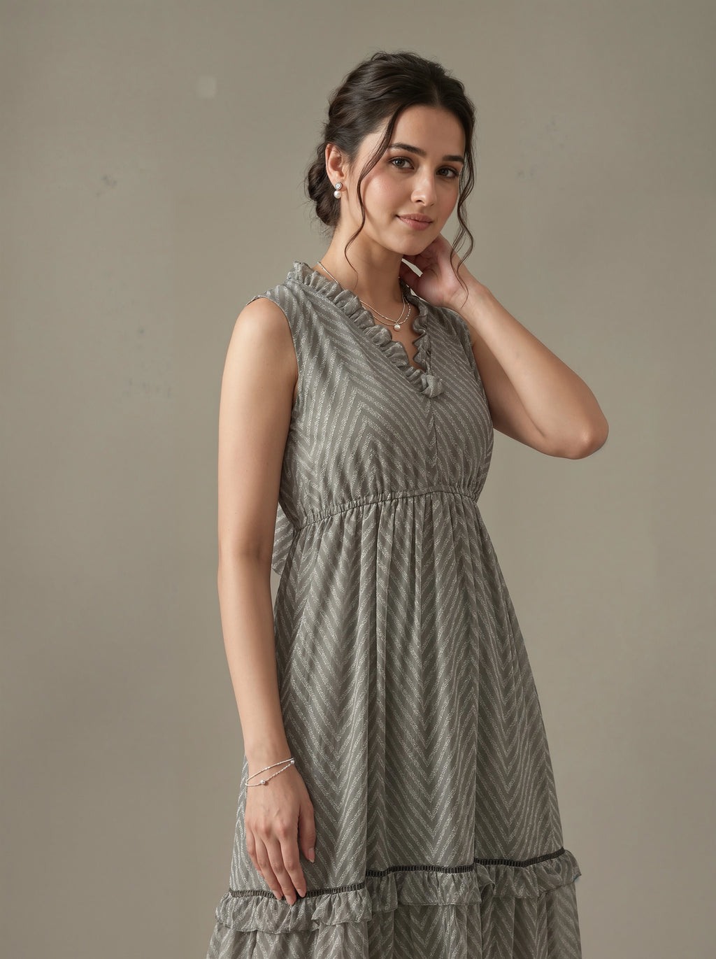 Woman wearing a gray patterned dress against a plain background