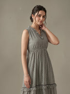 Woman wearing a gray patterned dress against a plain background